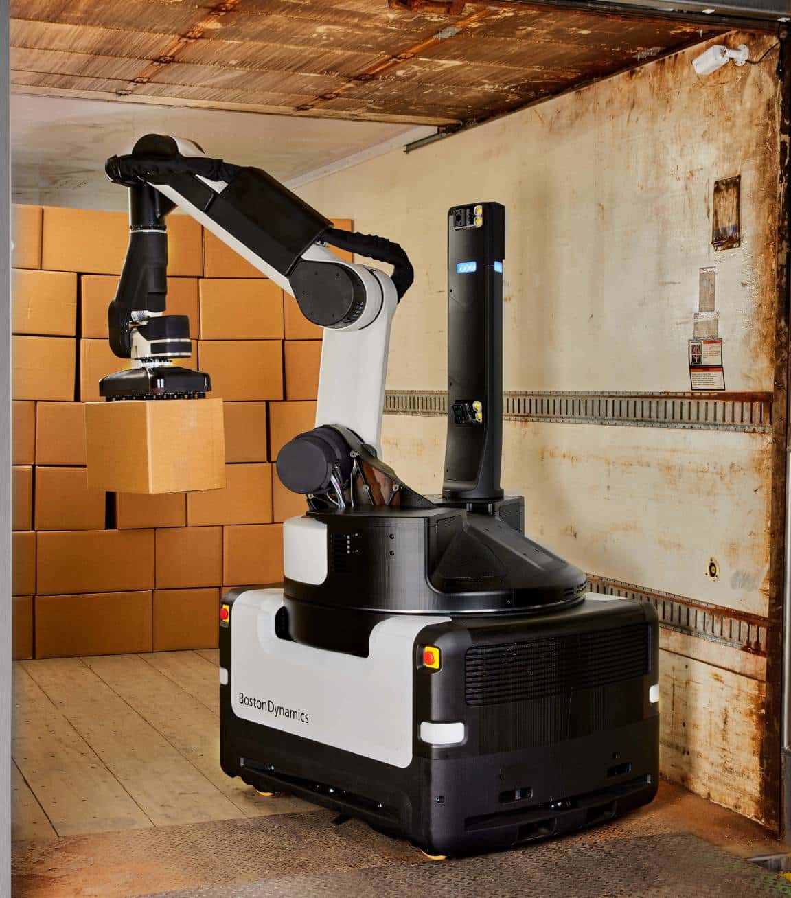 Stretch picking up a box from stacked cases in a trailer